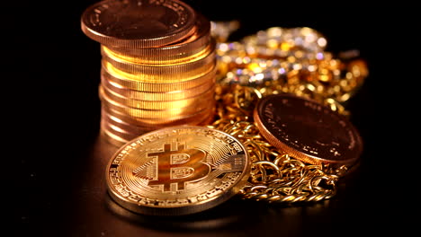 next to a pile of gold coins lies a bitcoin coin, a krugerrand gold coin and a diamond studded gold chain