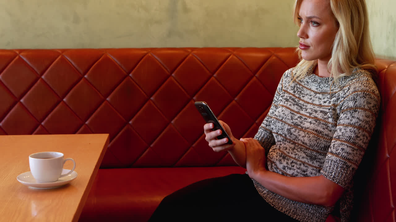 Beautiful woman using mobile phone at table 4k