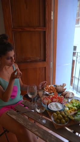 woman enjoying a meal on a balcony