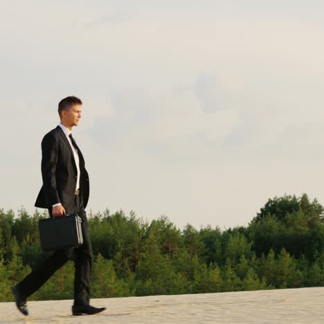 a businessman with a case in his hand walks along a sandy beach