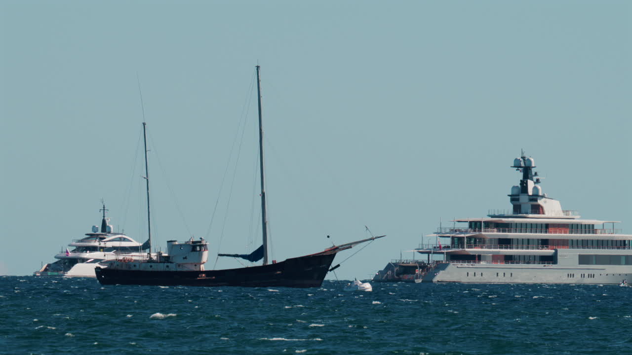 Multiple luxury yachts anchored on the blue Mediterranean Sea near the French Riviera coast