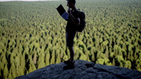 man with laptop on mountain top