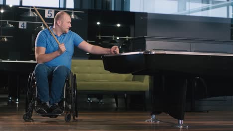 adult men with disabilities in a wheelchair play billiards in the club