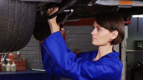 mecánica reparando una rueda de coche