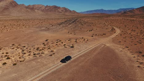 driving a modern black car on desert dirt road off-road in nevada close to death valley