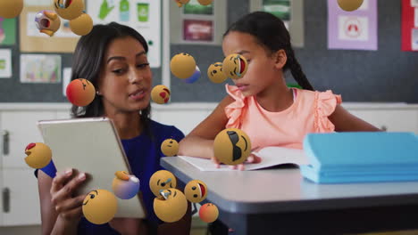 animación de íconos emoji sobre escolar biracial y maestra usando una tableta
