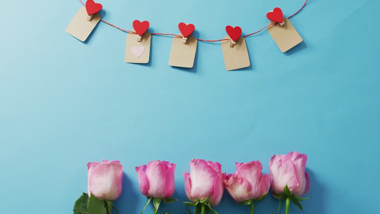 Paper hearts and roses on blue background at valentine's day