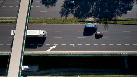 Antenne-Von-Oben-Nach-Unten---Verfolgung-Von-Autos,-Die-Sich-Auf-Einer-Schnellstraße-Bewegen---Weißer-LKW-Mit-Anhänger---Kommunikation-Und-Transport-Auf-Einer-Modernen-Straße