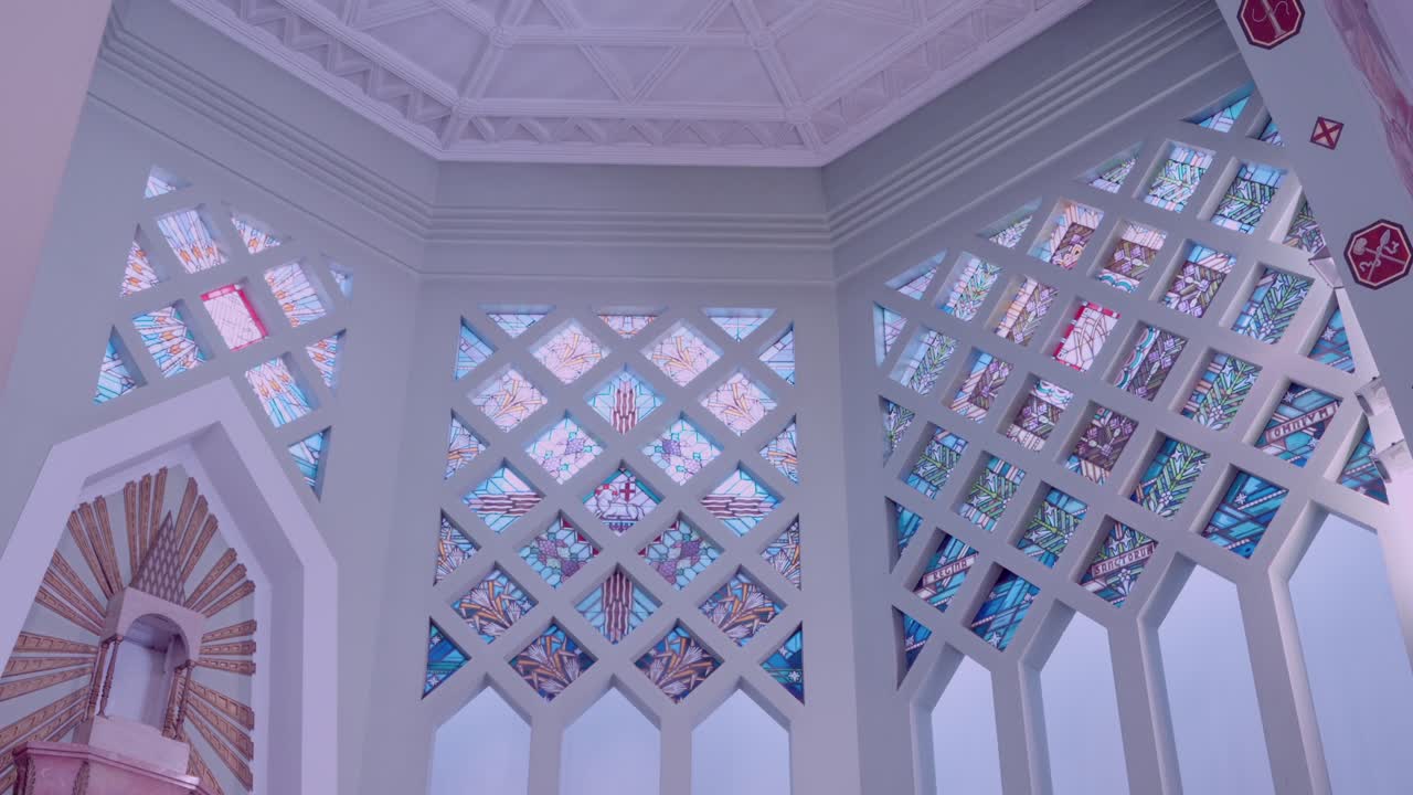 Detailed stained glass windows with geometric patterns in a cathedral interior