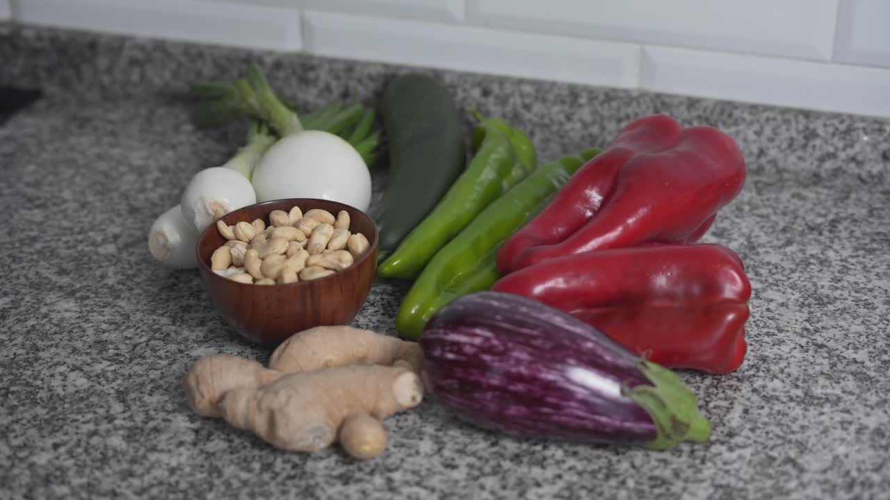 Assortment of fresh vegetables and cashews on a kitchen counter