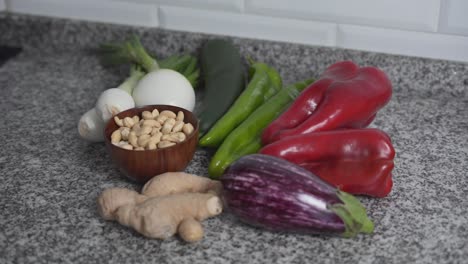 assortment of fresh vegetables and cashews on a kitchen counter