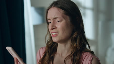 angry girlfriend talking mobile phone at home closeup. sad nervous woman crying