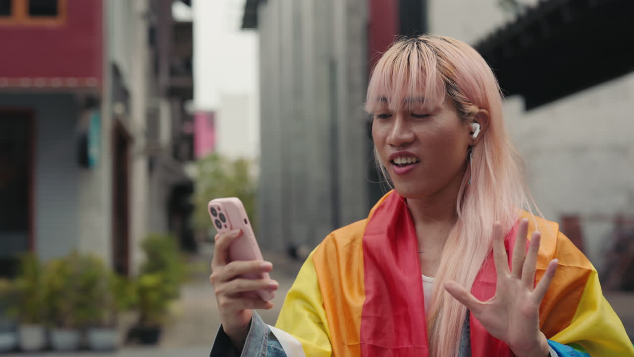 Transgender Person using Smartphone for Video Call, Rainbow Flag