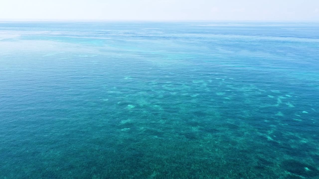 외딴 열대 지역의 산호 삼각지대에 있는 수정처럼 맑은 물과 함께 산호초와 아름다운 푸른 바다를 가로지르는 공중 드론 비행