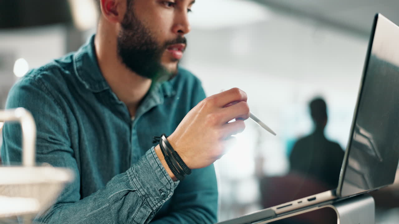 Man working on a laptop with a digital pen