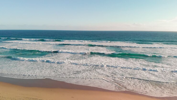 Drone view of beautiful sea waves on the beach, Aerial view of ocean shoreline, deep blue ocean water and foamy waves