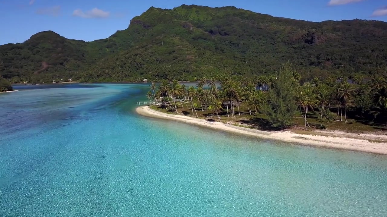 Luftfoto fra drone af Fransk Polynesien, der viser turkise lagunevande, hvide sandstrande og frodige palmeskove mod grønne vulkanske bjerge. Øerne Bora Bora, Huahine, Tahiti, Rangiroa.