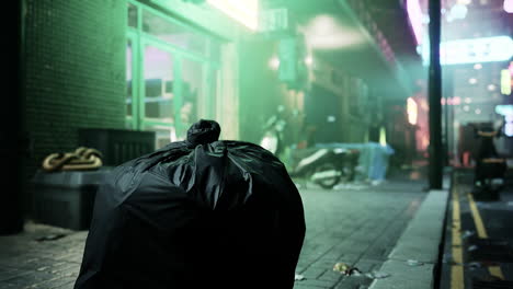 trash bag on a dark city street at night