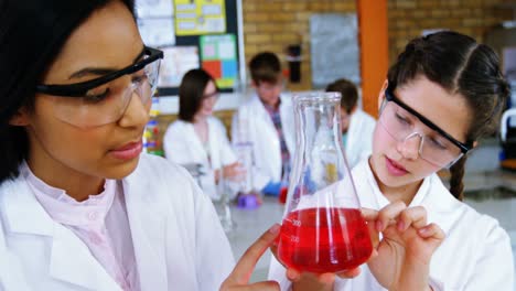 niñas experimentando con productos químicos en el laboratorio de la escuela