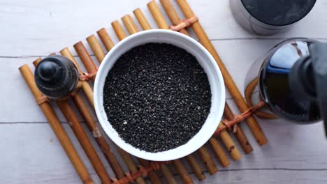 black cumin seeds and oil in a container on table