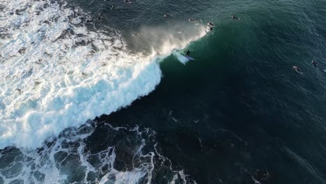 surfer riding huge wave at sunset