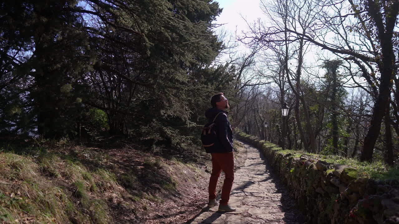 hombre caminando por un camino de piedra a través de un parque