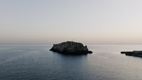 Luftaufnahmen-Im-Sonnenaufgang,-Der-Sich-Von-Der-Kleinen-Insel-Scoglio-Dell&#39;Eremita-In-Süditalien-Entfernt