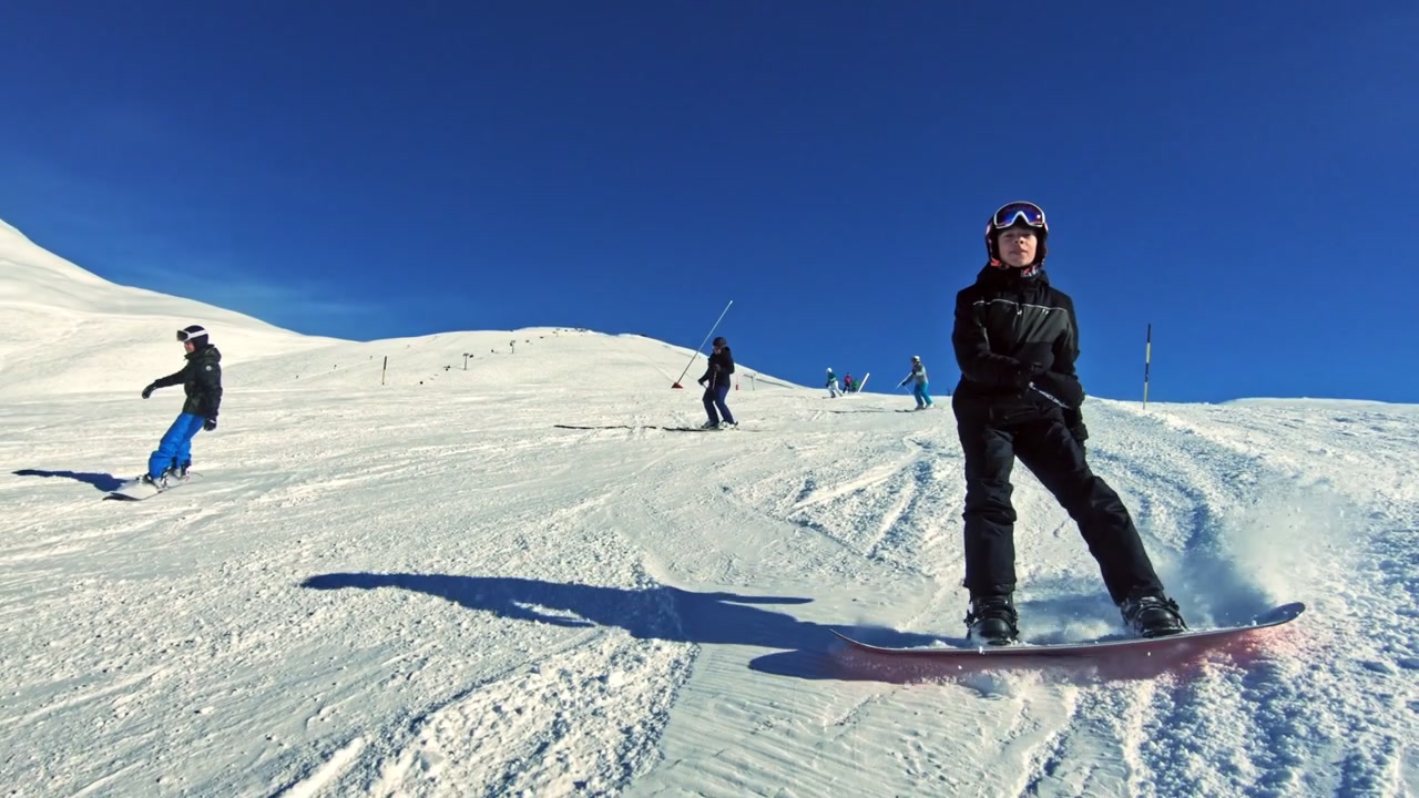 Adolescente felice che fa snowboard in vacanza invernale