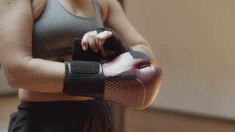 close-up shot of womans hands putting on boxing gloves