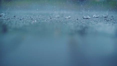 slow motion rain splashes in upper third while blurred surface adds depth calm