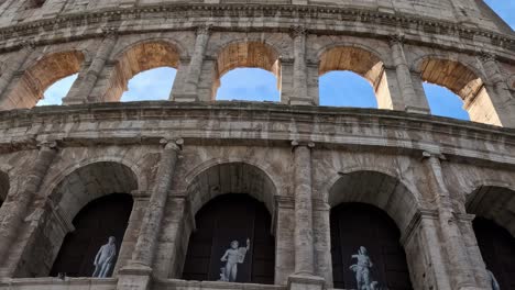close-up of the colosseum's arches featuring statues and architectural details under a clear sky.