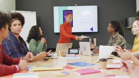 Happy-diverse-business-people-discussing-work-during-meeting-at-office