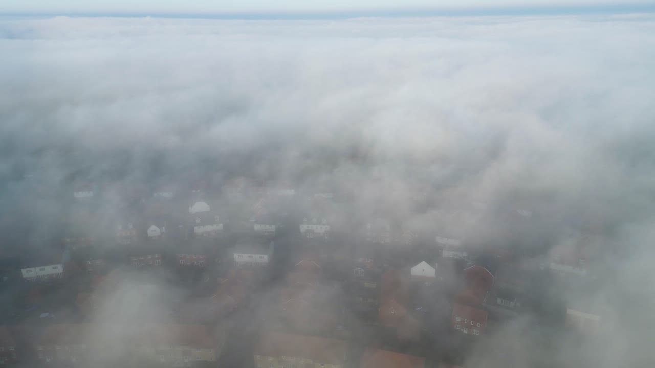 아래에 집이 있는 빠르게 구르는 안개의 정적 드론 영상