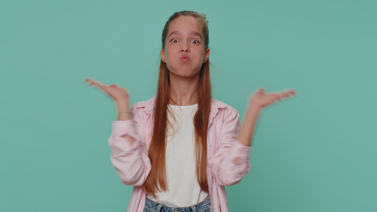 재미있는 소녀는 장난스러운 어리석은 얼굴 표정을 하고 미소 짓고, 어리석고, 혀를 보여줍니다.