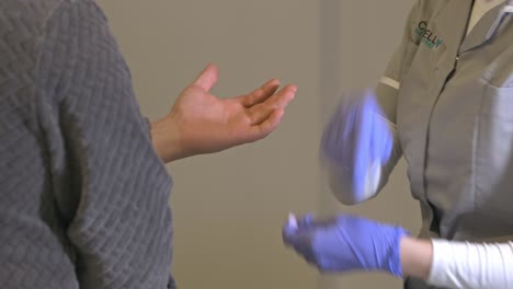 enfermera con guantes protectores tomando muestras de sangre del dedo para análisis de laboratorio