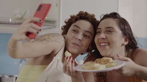 two women taking a selfie while eating food