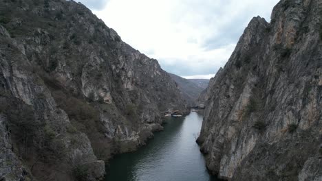 Aerial-shot-of-Treska-river-running-through-Matka-canyon,-natural-beauty-at-the-junction-of-the-mountains