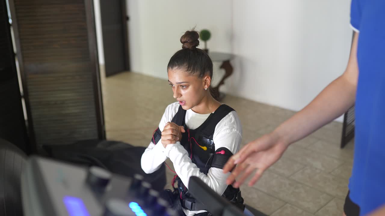 mujer usando una máquina de fitness con entrenador