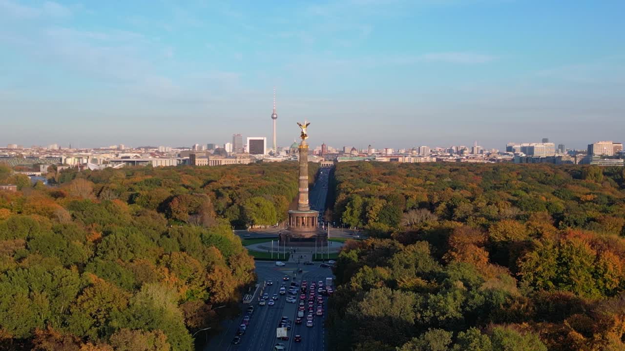 iconic landmark surrounded by colorful autumn foliage, with the cityscape in the background under a clear blue sky. Gorgeous aerial view flight descending drone
