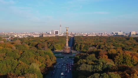 iconic landmark surrounded by colorful autumn foliage, with the cityscape in the background under a clear blue sky. gorgeous aerial view flight descending drone