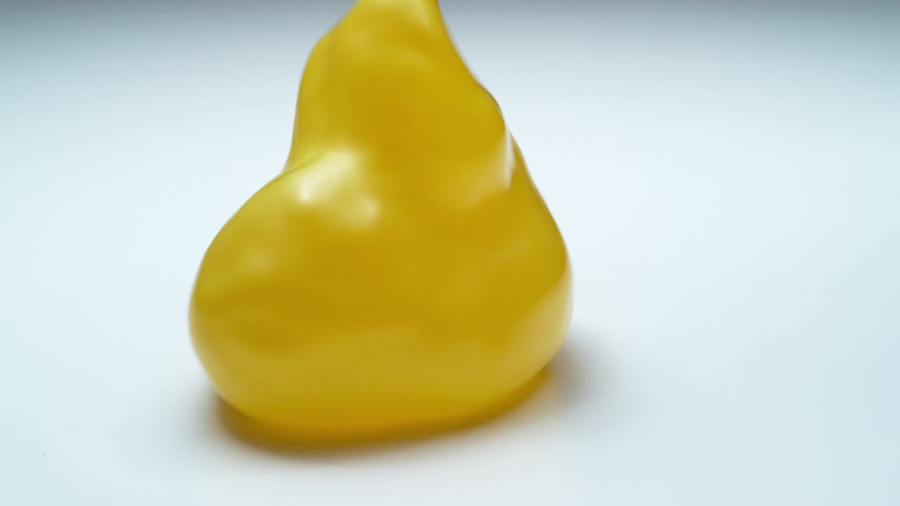 Gelber Wasserballon hüpft in Superzeitlupe. Aufgenommen mit Phantom Flex 4K.