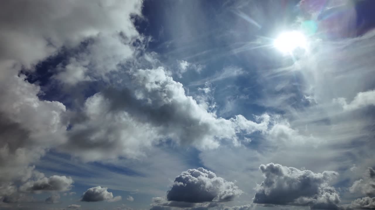 An immersive POV aerial cloudscape taken from a jet cockpit flying at supersonic speed, under crispy cumulus clouds illuminated by a radiant sunlight in a blue sky. Ultra-realistic 4K shot.