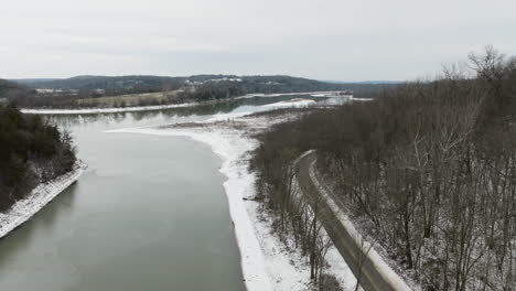 bare trees along the river and empty road during winter in fayetteville, arkansas, usa