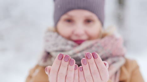 retrato de una mujer que atrapa la nitidez de los copos de nieve al alcance de su mano