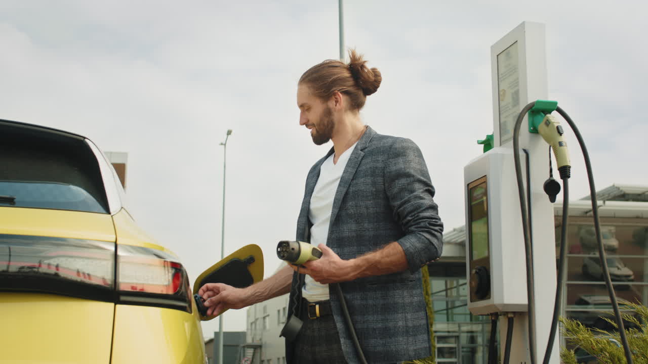 충전소 에서 전기 차량 을 충전 하는 사람