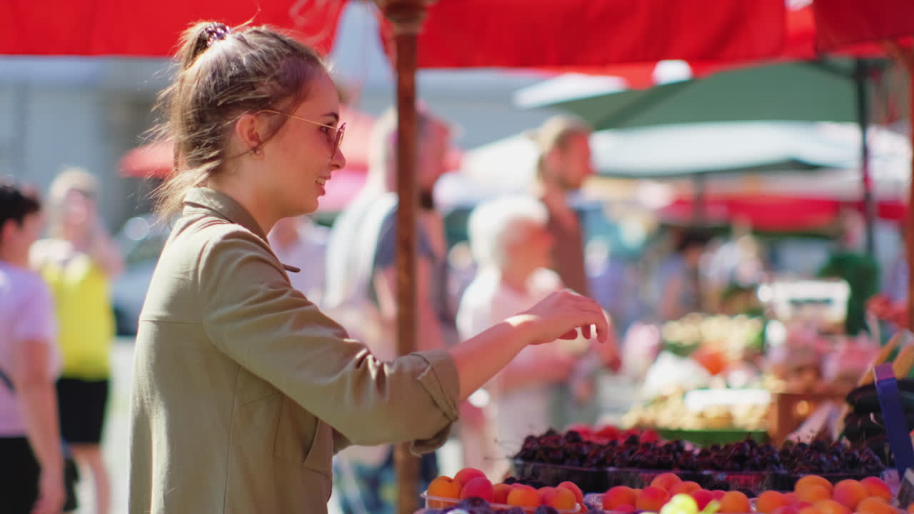 mujer comprando frutas en un mercado de agricultores de verano