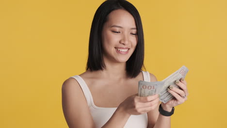 Asian-woman-counting-money-on-camera.