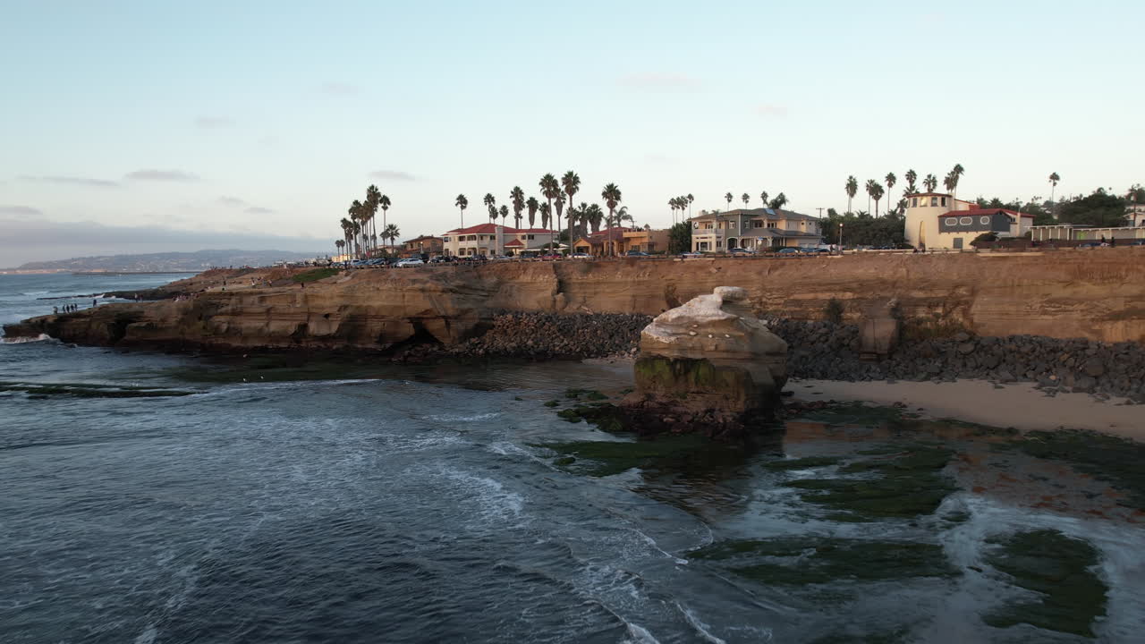 vista aérea, las olas del océano pacífico rompiendo en la costa de california bajo el barrio de los acantilados de san diego, disparo de drones