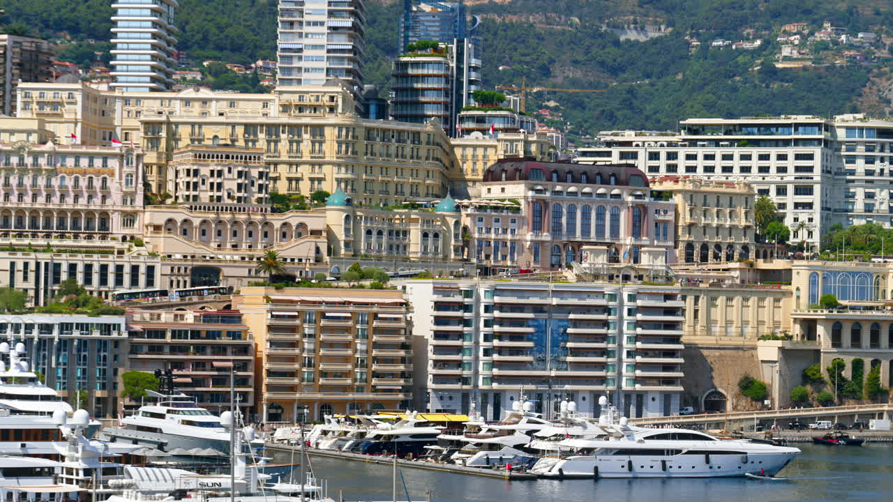 View of boats docked in the Monaco Marina with the skyline of the city on the background