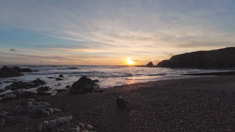 Cámara-Lenta-Cinematográfica-Olas-Doradas-Marea-Entrante-Hora-Dorada-En-La-Playa-De-Guijarros-Costa-De-Cobre-Waterford-Irlanda-En-Un-Día-De-Invierno